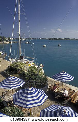 cafT, Bermuda, St. George's Parish, Wharf's Tavern outdoor cafT with blue and white umbrellas overlooking the aqua blue water of St. George's Harbor in St George in Bermuda. View Large Photo Image Stock Photo - cafT, Bermuda, St. George's Parish, Wharf's Tavern outdoor cafT with blue and white umbrellas overlooking the aqua blue water of St. George's Harbor in St George in Bermuda. . Fotosearch