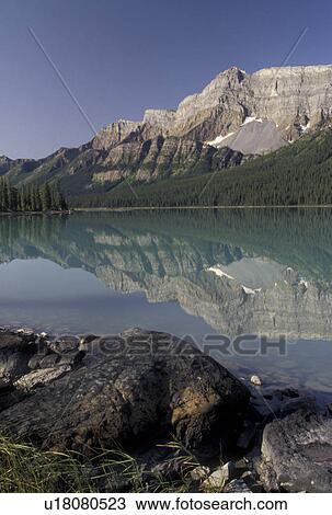 Canada, Banff National Park, Alberta, Canadian Rockies, Reflection of the surrounding mountains in the calm waters of Hector Lake in Banff National Park in Alberta. View Large Photo Image Stock Image - Canada, Banff National Park, Alberta, Canadian Rockies, Reflection of the surrounding mountains in the calm waters of Hector Lake in Banff National Park in Alberta.. Fotosearch