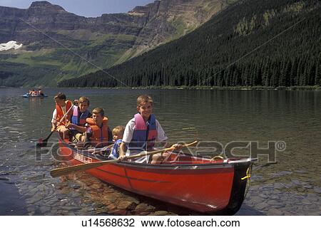 canoeing, Canada, Alberta, Waterton Lakes National Park, Canadian Rockies, A group of boys and their sister paddle a red canoe on Cameron Lake in Waterton-Glacier International Peace Park in Alberta. View Large Photo Image Stock Image - canoeing, Canada, Alberta, Waterton Lakes National Park, Canadian Rockies, A group of boys and their sister paddle a red canoe on Cameron Lake in Waterton-Glacier International Peace Park in Alberta.. Fotosearch