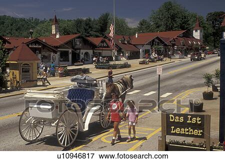 Stock Photo -  carriage ride, Alpine Village, Helen, GA, Georgia, Mother and nine year old daughter walk by horse-drawn carriage in the alpine village of Helen in North Georgia.. Fotosearch