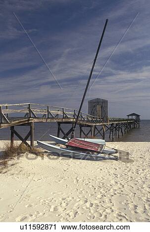 Stock Image -  catamaran, Gulfport, Mississippi, MS, Gulf of Mexico, A catamaran rests on the beach in Gulfport on the Gulf of Mexico.. Fotosearch