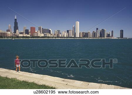 Chicago, IL, lakeshore, Illinois, Lake Michigan, Scenic view of Chicago Harbor and the downtown skyline from Grant Park in Chicago. Woman walking along the lakeshore recreational path. View Large Photo Image Stock Photography - Chicago, IL, lakeshore, Illinois, Lake Michigan, Scenic view of Chicago Harbor and the downtown skyline from Grant Park in Chicago. Woman walking along the lakeshore recreational path.. Fotosearch