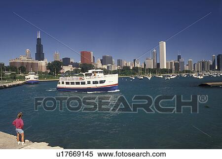 Chicago, IL, tour boat, Lake Michigan, Illinois, skyline, Woman watching a sightseeing tour boat in the Chicago Harbor from Grant Park with a view of the downtown skyline of Chicago. View Large Photo Image Stock Photography - Chicago, IL, tour boat, Lake Michigan, Illinois, skyline, Woman watching a sightseeing tour boat in the Chicago Harbor from Grant Park with a view of the downtown skyline of Chicago. . Fotosearch