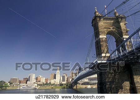 Stock Photo -  Cincinnati, OH, bridge, skyline, Ohio, Ohio River, Downtown skyline of Cincinnati and John A. Roebling Suspension Bridge crossing the Ohio River.. Fotosearch