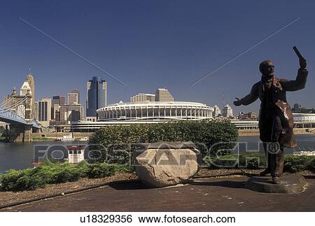 Cincinnati, OH, Ohio, Statue of John A. Roebling and view of downtown skyline of Cincinnati and Cinergy Field, home of the Cincinnati Reds, along the Ohio River. View Large Photo Image Stock Photograph - Cincinnati, OH, Ohio, Statue of John A. Roebling and view of downtown skyline of Cincinnati and Cinergy Field, home of the Cincinnati Reds, along the Ohio River.. Fotosearch