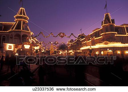 Stock Photograph -  Disney World, FL, Orlando, Magic Kingdom, Lake Buena Vista, Florida, A crowd of people walk down Main Street U. S. A. in the evening during the Christmas holidays in the Magic Kingdom at Walt Disney World in Lake Buena Vista.. Fotosearch