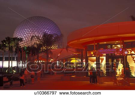Stock Photo -  Disney World, Orlando, FL, Epcot, Lake Buena Vista, Florida, Gift shops and Spaceship Earth illuminated at night in Epcot Center at Walt Disney World in Lake Buena Vista. . Fotosearch