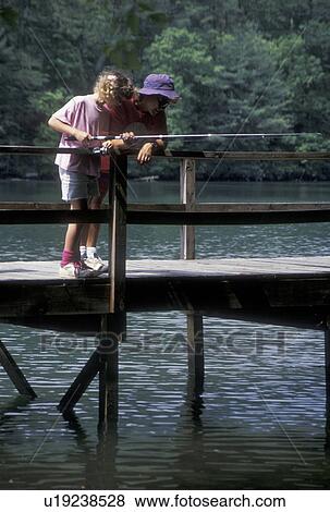 Stock Photo -  fishing, lake, Chattahoochee National Forest, GA, Georgia, Mother and nine year old daughter fishing off a dock on Lake Tallulah in the Chattahoochee National Forest in North Georgia.. Fotosearch