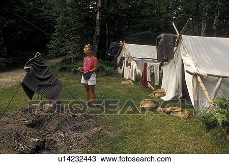 Stock Image -  forestry, Grand Rapids, MN, Minnesota, Woman takes a look at the reenactment camp at the 19th-century Logging Camp at the Forest History Center in Grand Rapids.. Fotosearch