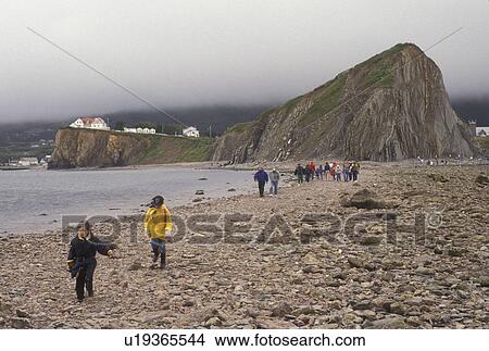 Gaspe Peninsula, Perce, Quebec, Canada, Rocher Perce, Gulf of St. Lawrence, People walking to and from Rocher Perce (Perce Rock) at low tide on the Gulf of St. Lawrence in Perce on Gaspe Peninsula in Quebec. View Large Photo Image Picture - Gaspe Peninsula, Perce, Quebec, Canada, Rocher Perce, Gulf of St. Lawrence, People walking to and from Rocher Perce (Perce Rock) at low tide on the Gulf of St. Lawrence in Perce on Gaspe Peninsula in Quebec.. Fotosearch