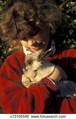 girl, rabbit, Young nine year old girl with red sweatshirt cuddles her Netherland Dwarf bunny in her arms in Atlanta, GA. View Large Photo Image Stock Photograph - girl, rabbit, Young nine year old girl with red sweatshirt cuddles her Netherland Dwarf bunny in her arms in Atlanta, GA.. Fotosearch