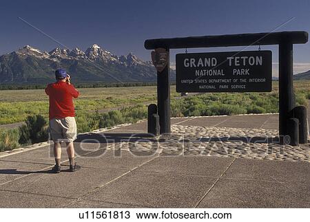 Grand Teton National Park, WY, Wyoming, Man taking pictures at the entrance to Grand Teton Nat'l Park with a view of the Grand Tetons in the background in Wyoming. View Large Photo Image Stock Image - Grand Teton National Park, WY, Wyoming, Man taking pictures at the entrance to Grand Teton Nat'l Park with a view of the Grand Tetons in the background in Wyoming.. Fotosearch