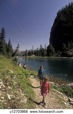Stock Photo -  hiking, Banff National Park, Canada, Alberta, Canadian Rockies, Mother and daughter hiking along Lake Agnes in Banff National Park in Alberta.. Fotosearch