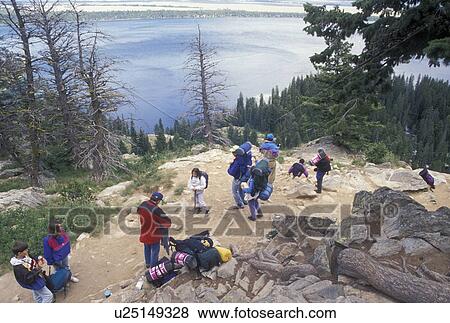 Stock Photo -  hiking, Grand Teton National Park, Jenny Lake, WY, Jackson Hole, Wyoming, Hikers on Inspiration Point on Jenny Lake in Grand Teton Nat'l Park in Wyoming.. Fotosearch