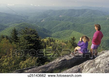 Stock Image -  hiking, mountains NC, Blue Ridge Parkway, North Carolina, Mother and nine year old daughter at Devil's Courthouse Overlook along the Blue Ridge Parkway in North Carolina. Young girl looking with binoculars.. Fotosearch