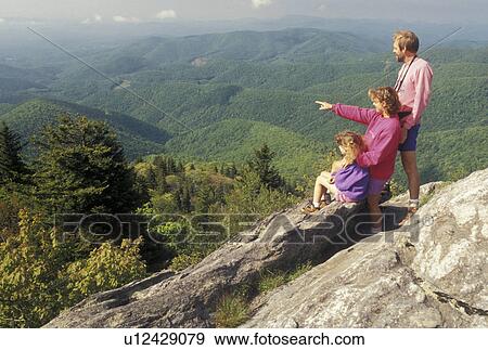 Stock Photo -  hiking, mountains NC, Blue Ridge Parkway, North Carolina, Mother, father and nine year old daughter at Devil's Courthouse Overlook along the Blue Ridge Parkway in North Carolina. Woman looking with binoculars.. Fotosearch