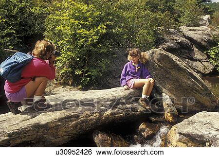 hiking, NC, Pisgah National Forest, North Carolina, Mother takes a picture of her nine year old daughter as they take a break at Second Falls at Graveyard Fields in Pisgah National Forest in North Carolina. View Large Photo Image Stock Photograph - hiking, NC, Pisgah National Forest, North Carolina, Mother takes a picture of her nine year old daughter as they take a break at Second Falls at Graveyard Fields in Pisgah National Forest in North Carolina.. Fotosearch