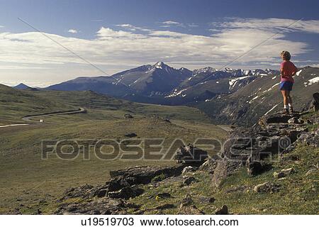 Stock Image -  hiking, Rocky Mountain National Park, CO, Colorado, Rockies, Woman looking a the scenic view of the mountains and valley and scenic Trail Ridge Road in Rocky Mountain National Park.. Fotosearch