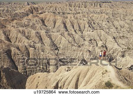 hiking, The Badlands, Badlands National Park, SD, South Dakota, A couple looking at the spectacular landscape of rock formations in Badlands Nat'l Park in South Dakota. View Large Photo Image Picture - hiking, The Badlands, Badlands National Park, SD, South Dakota, A couple looking at the spectacular landscape of rock formations in Badlands Nat'l Park in South Dakota.. Fotosearch