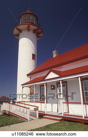 Stock Photograph -  lighthouse, Gaspe Peninsula, Quebec, Metis-sur-Mer, Canada, Gulf of St. Lawrence, Pointe-de-Mitis Lighthouse with red roof in Metis-Sur-Mer along the St. Lawrence River on the Gaspe Peninsula in Quebec.. Fotosearch