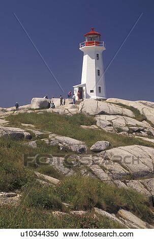 Stock Image -  lighthouse, Peggy's Cove, fishing village, Nova Scotia, NS, Canada, Atlantic Ocean, The old lighthouse stands on top of a massive granite rock in Peggy's Cove in Nova Scotia. . Fotosearch