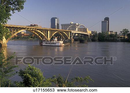 Little Rock, skyline, AR, Arkansas, A riverboat cruises under a bridge crossing the Arkansas River and a view of the downtown skyline of Little Rock. View Large Photo Image Stock Image - Little Rock, skyline, AR, Arkansas, A riverboat cruises under a bridge crossing the Arkansas River and a view of the downtown skyline of Little Rock.. Fotosearch