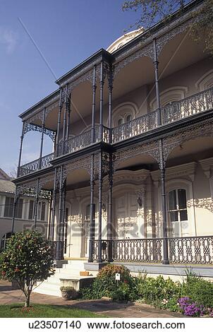 Stock Image -  mansion, Garden District, New Orleans, LA, Louisiana, Ornate mansion with cast iron railings in the Garden District in New Orleans. . Fotosearch