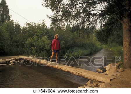 Mississippi River, Itasca State Park, MN, Minnesota, Park Rapids, A woman walks across the bridge that crosses the narrow headwaters of the Mississippi River in Itasca State Park. View Large Photo Image Picture - Mississippi River, Itasca State Park, MN, Minnesota, Park Rapids, A woman walks across the bridge that crosses the narrow headwaters of the Mississippi River in Itasca State Park.. Fotosearch