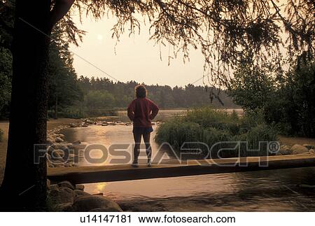 Mississippi River, Itasca State Park, MN, Minnesota, Park Rapids, Lake Itasca, A woman standing on a bridge that crosses the narrow headwaters of the Mississippi River at sunrise in Itasca State Park. View Large Photo Image Stock Image - Mississippi River, Itasca State Park, MN, Minnesota, Park Rapids, Lake Itasca, A woman standing on a bridge that crosses the narrow headwaters of the Mississippi River at sunrise in Itasca State Park.. Fotosearch