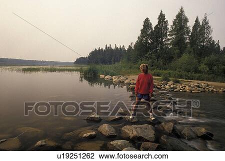 Mississippi River, Itasca State Park, MN, Minnesota, Park Rapids, Lake Itasca, A woman walks across the narrow headwaters of the Mississippi River on large rocks in Itasca State Park. View Large Photo Image Stock Image - Mississippi River, Itasca State Park, MN, Minnesota, Park Rapids, Lake Itasca, A woman walks across the narrow headwaters of the Mississippi River on large rocks in Itasca State Park.. Fotosearch