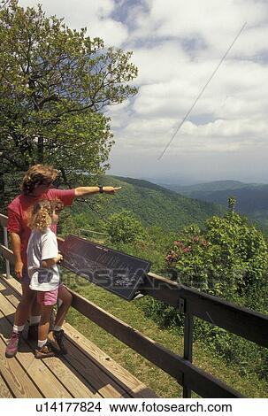 Picture -  NC, Pisgah National Forest, North Carolina, Mother points showing her nine year old daughter the scenic view of the mountains at Pisgah Lodge overlook off of the Blue Ridge Parkway in North Carolina.. Fotosearch