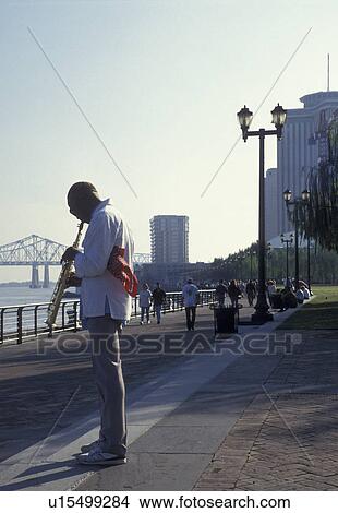 Picture -  New Orleans, jazz, street artist, LA, Mississippi River, Riverfront Park, waterfront, Louisiana, A street musician plays his instrument on Waldenberg Riverfront Park along the Mississippi River in New Orleans. . Fotosearch