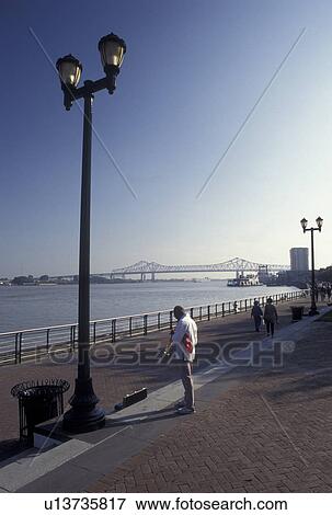 New Orleans, Mississippi River, Riverfront Park, LA, waterfront, Louisiana, A street musician plays his instrument on Waldenberg Riverfront Park along the Mississippi River in New Orleans. View Large Photo Image Stock Photo - New Orleans, Mississippi River, Riverfront Park, LA, waterfront, Louisiana, A street musician plays his instrument on Waldenberg Riverfront Park along the Mississippi River in New Orleans. . Fotosearch
