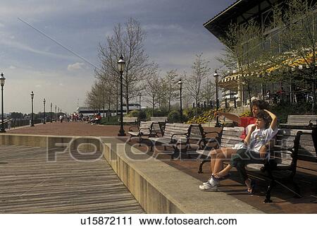 Norfolk, VA, Hampton Roads Area, Virginia, Mother and daughter sitting on a park bench at The Waterside in Norfolk in the spring. View Large Photo Image Stock Image - Norfolk, VA, Hampton Roads Area, Virginia, Mother and daughter sitting on a park bench at The Waterside in Norfolk in the spring.. Fotosearch