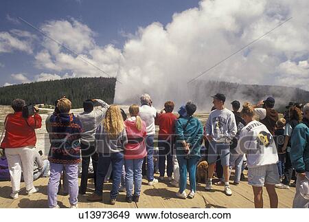 Stock Photo -  Old Faithful, Yellowstone National Park, WY, geyser, Wyoming, A crowd of people watching Old Faithful erupt in Yellowstone Nat'l Park in Wyoming.. Fotosearch