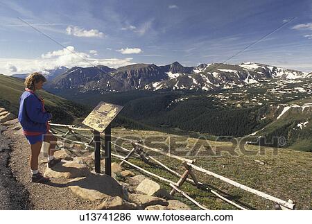 Stock Photograph -  overlook, Rocky Mountain National Park, CO, Colorado, Woman reading sign at scenic overlook on Scenic Trail Ridge Road in Rocky Mountain Nat'l Park.. Fotosearch