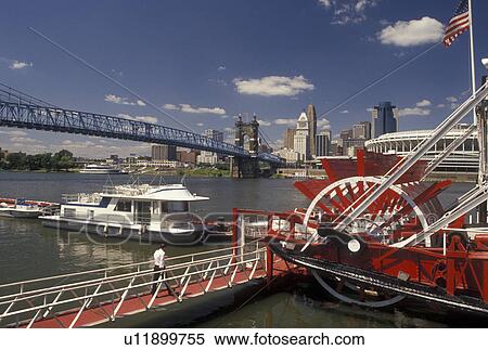 Stock Photography -  riverboat, Cincinnati, OH, Ohio, Ohio River, Mike Fink's Riverboat Restaurant along the Ohio River with a view of the downtown skyline of Cincinnati and Cinergy Field, home of the Cincinnati Reds.. Fotosearch