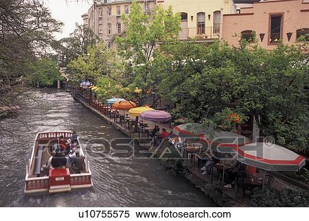 San Antonio, The Riverwalk, TX, Texas, A tour boat cruises past outdoor cafes and restaurants along Paseo Del Rio, The Riverwalk, in downtown San Antonio in the evening. View Large Photo Image Stock Photography - San Antonio, The Riverwalk, TX, Texas, A tour boat cruises past outdoor cafes and restaurants along Paseo Del Rio, The Riverwalk, in downtown San Antonio in the evening. . Fotosearch