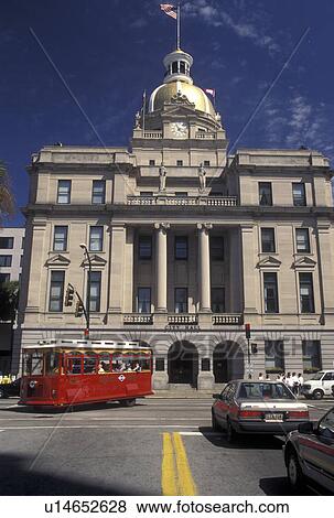Stock Photo -  Savannah, GA, Georgia, Red trolley Grey Line Tours tour bus passes outside City Hall on the Historic River Front in Savannah. . Fotosearch