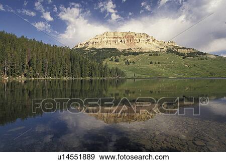 Stock Photo -  Shoshone National Forest, WY, Wyoming, Reflection of mountain butte in the calm waters of Beartooth Lake in the Shoshone Nat'l Forest in Wyoming.. Fotosearch