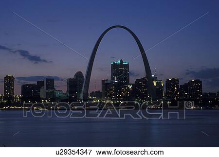 Stock Photo -  St. Louis, MO, Gateway Arch, Missouri, View of the Gateway Arch and downtown skyline of Saint Louis along the Mississippi River at sunset. . Fotosearch