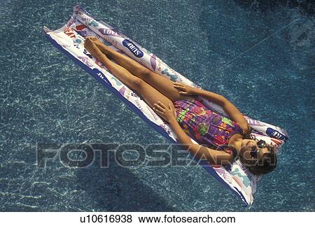 swimming, pool, girl, 8 year old girl with sun glasses in a bathing suit lying on her back on a float in a swimming pool. View Large Photo Image Stock Photo - swimming, pool, girl, 8 year old girl with sun glasses in a bathing suit lying on her back on a float in a swimming pool.. Fotosearch