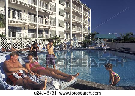 swimming pool, hotel, Florida Keys, Key West, FL, Gulf of Mexico, Florida, Atlantic Ocean, Young couple sunbathing next to a swimming pool at a hotel in Key West. Young children swimming in the pool. View Large Photo Image Stock Image - swimming pool, hotel, Florida Keys, Key West, FL, Gulf of Mexico, Florida, Atlantic Ocean, Young couple sunbathing next to a swimming pool at a hotel in Key West. Young children swimming in the pool.. Fotosearch