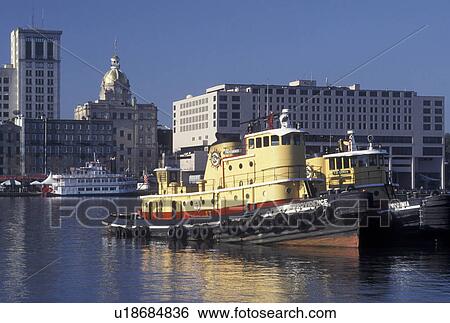 Stock Photograph -  tugboat, Savannah, GA, Georgia, Tugboats on the Savannah River with view of downtown Savannah.. Fotosearch