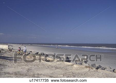 Tybee Island, GA, Atlantic Ocean, Savannah, Georgia, People walking and biking on the beach on Tybee Island in Georgia View Large Photo Image Stock Photography - Tybee Island, GA, Atlantic Ocean, Savannah, Georgia, People walking and biking on the beach on Tybee Island in Georgia. Fotosearch