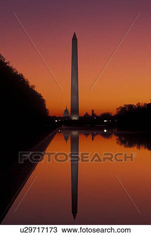 Stock Image -  Washington Monument, The National Mall, sunrise, Washington, DC, District of Columbia, The Washington Monument reflects in the reflecting Pool at sunrise at the National Mall in Washington D. C.. Fotosearch