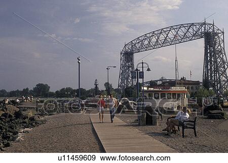 waterfront, boardwalk, Duluth, MN, Minnesota, Lake Superior, People walk on the boardwalk at Downtown Lakewalk along Lake Superior in Duluth. Aerial Lift Bridge in the background. View Large Photo Image Stock Photo - waterfront, boardwalk, Duluth, MN, Minnesota, Lake Superior, People walk on the boardwalk at Downtown Lakewalk along Lake Superior in Duluth. Aerial Lift Bridge in the background.. Fotosearch