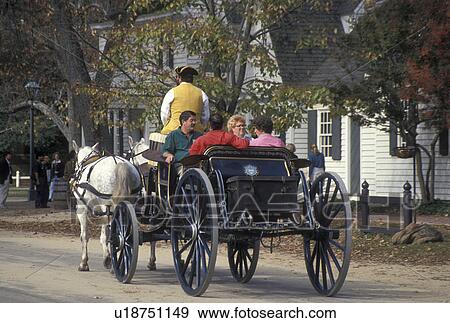 Williamsburg, VA, horse-drawn carriage, Colonial Williamsburg, Virginia, A team of horses pulling an open carriage carries tourists through the 18th century village of Colonial Williamsburg in Colonial Williamsburg Historic Area. View Large Photo Image Stock Photo - Williamsburg, VA, horse-drawn carriage, Colonial Williamsburg, Virginia, A team of horses pulling an open carriage carries tourists through the 18th century village of Colonial Williamsburg in Colonial Williamsburg Historic Area.. Fotosearch