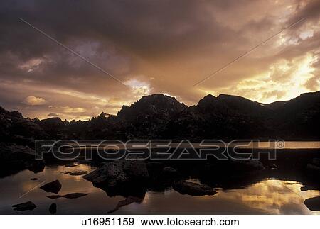 Wind River Range, sunrise, mountain lake, Bridger-Teton National Forest, WY, Wyoming, Reflection of the rocks and surrounding mountains in the calm waters of Island Lake at sunrise in the Wind River Range Mountains in the Bridger-Teton Nat'l Forest in Wy View Large Photo Image Stock Photo - Wind River Range, sunrise, mountain lake, Bridger-Teton National Forest, WY, Wyoming, Reflection of the rocks and surrounding mountains in the calm waters of Island Lake at sunrise in the Wind River Range Mountains in the Bridger-Teton Nat'l Forest in Wy. Fotosearch