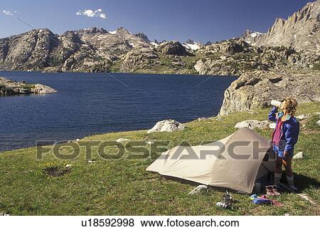 woman hiker, camping, Wind River Range, hiking, Bridger-Teton National Forest, WY, Wyoming, Woman backpacker taking a drink next to her tent at Island Lake in the Wind River Range Mountains in the Bridger-Teton Nat'l Forest in Wyoming. View Large Photo Image Stock Photo - woman hiker, camping, Wind River Range, hiking, Bridger-Teton National Forest, WY, Wyoming, Woman backpacker taking a drink next to her tent at Island Lake in the Wind River Range Mountains in the Bridger-Teton Nat'l Forest in Wyoming.. Fotosearch